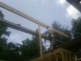 Carpenter setting a ridge beam over a new addition frame — Ice Dam Removal by Roofing Brothers in Old Lyme