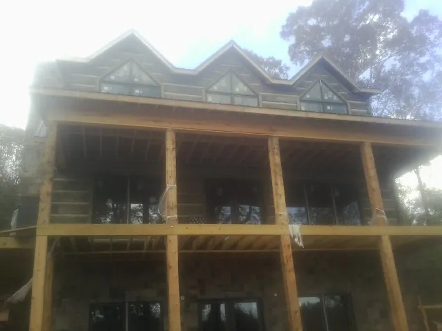 Dormers and porch framing on a large log home under construction — Roof Coating work by our crew in Old Lyme