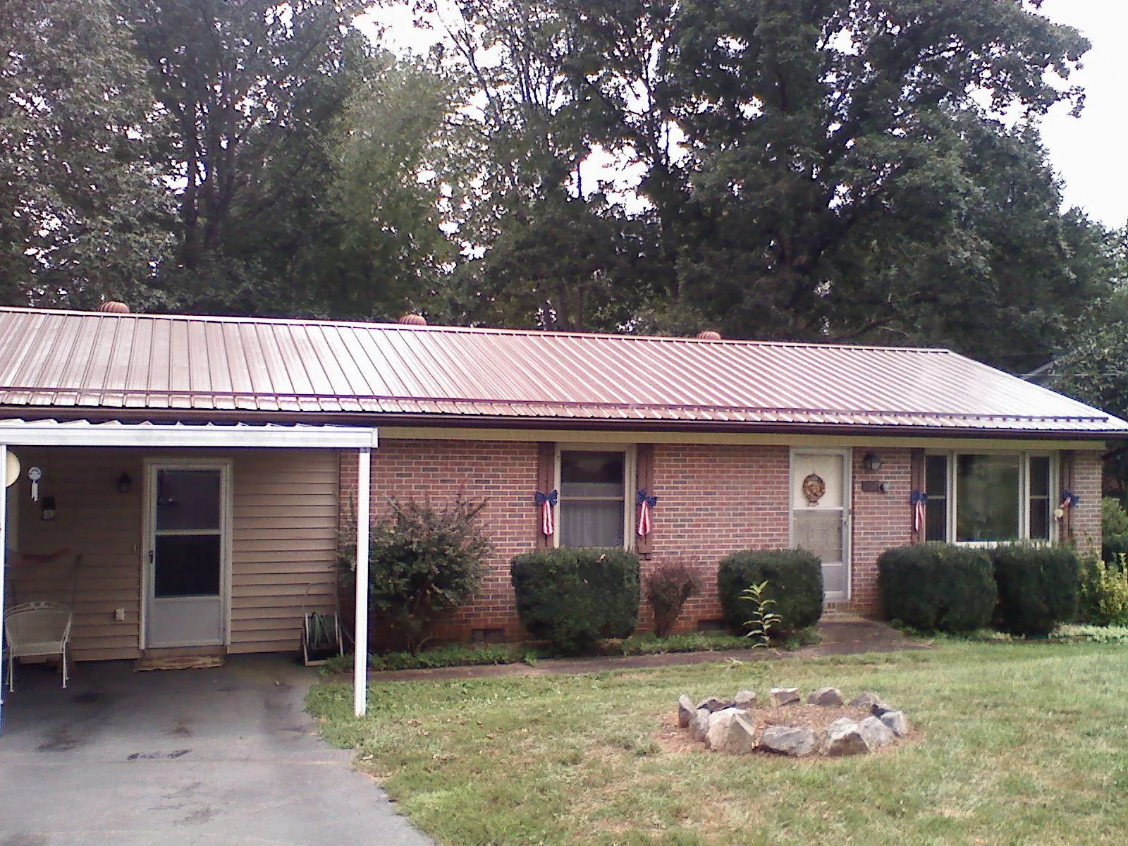 Bronze metal roof and carport on a brick ranch home — Roof Repair work by our crew in Old Lyme